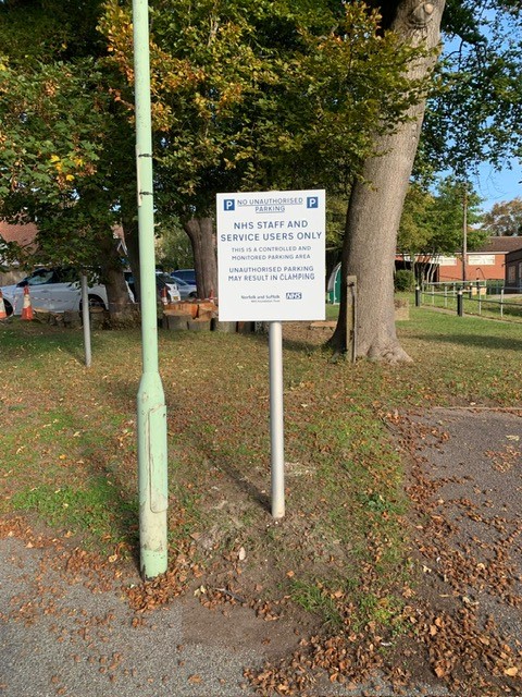 Professional parking restriction signage for NHS healthcare facility with controlled access