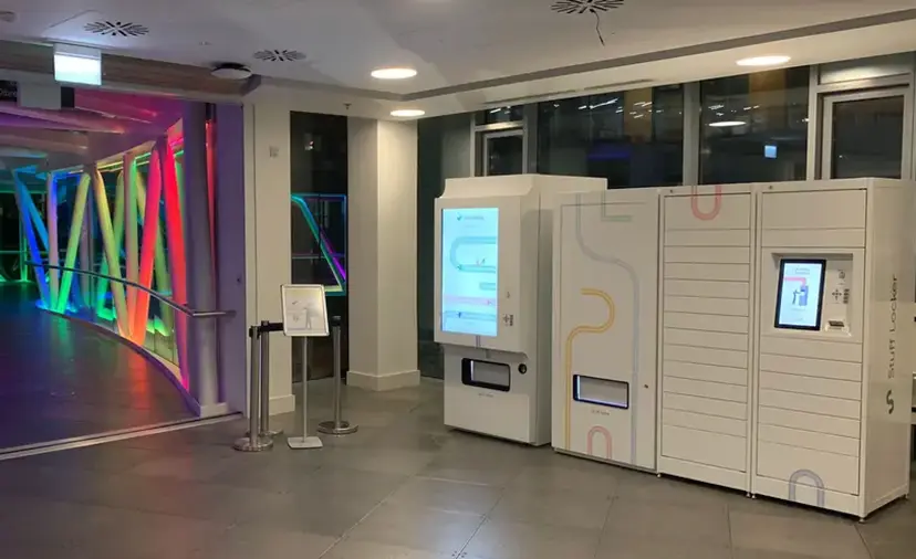 Hybrid office locker system with touchscreen booking panel alongside open shared lockers